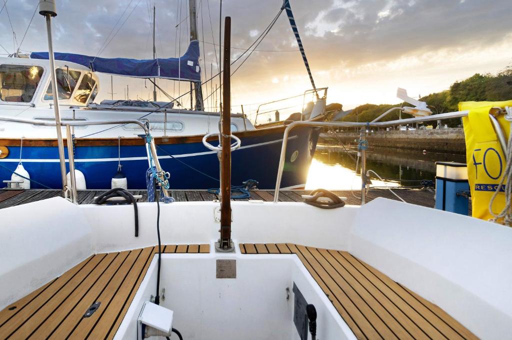 a boat docked at a dock with the sun setting at Happy Sailor in Viana do Castelo