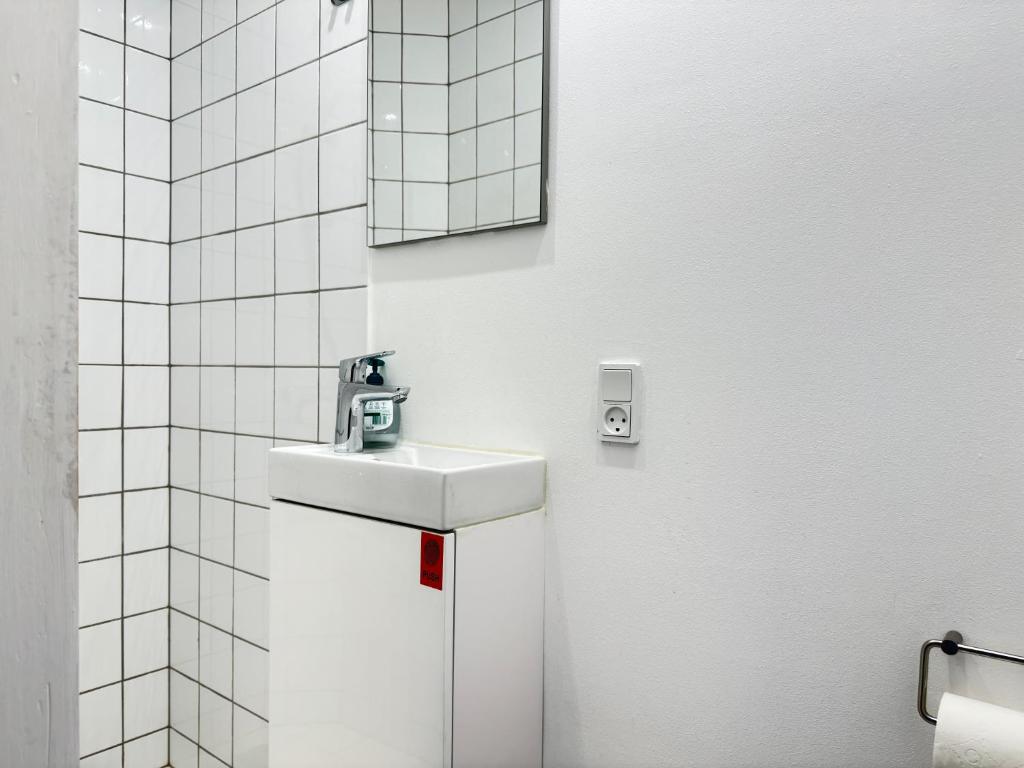 a white bathroom with a sink and a mirror at Perfect Apartment For Travelers On A Budget - But Still Wants Quality in Randers