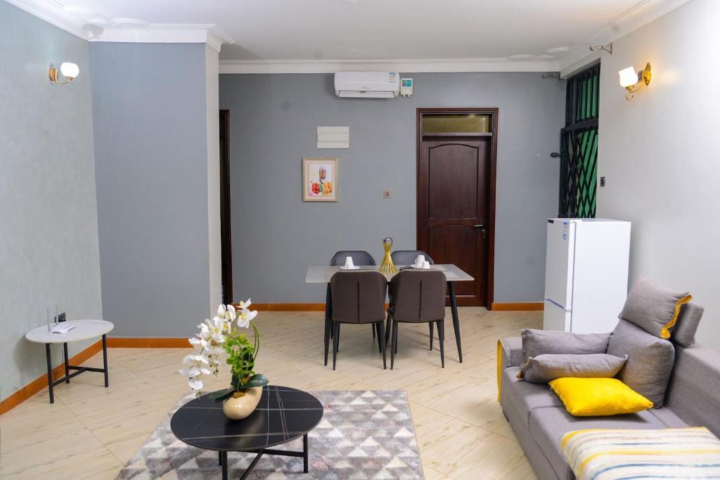 - un salon avec un canapé et une table dans l'établissement 2 Bedroom Suite In 3 Bedroom Apartment, à Namulanda