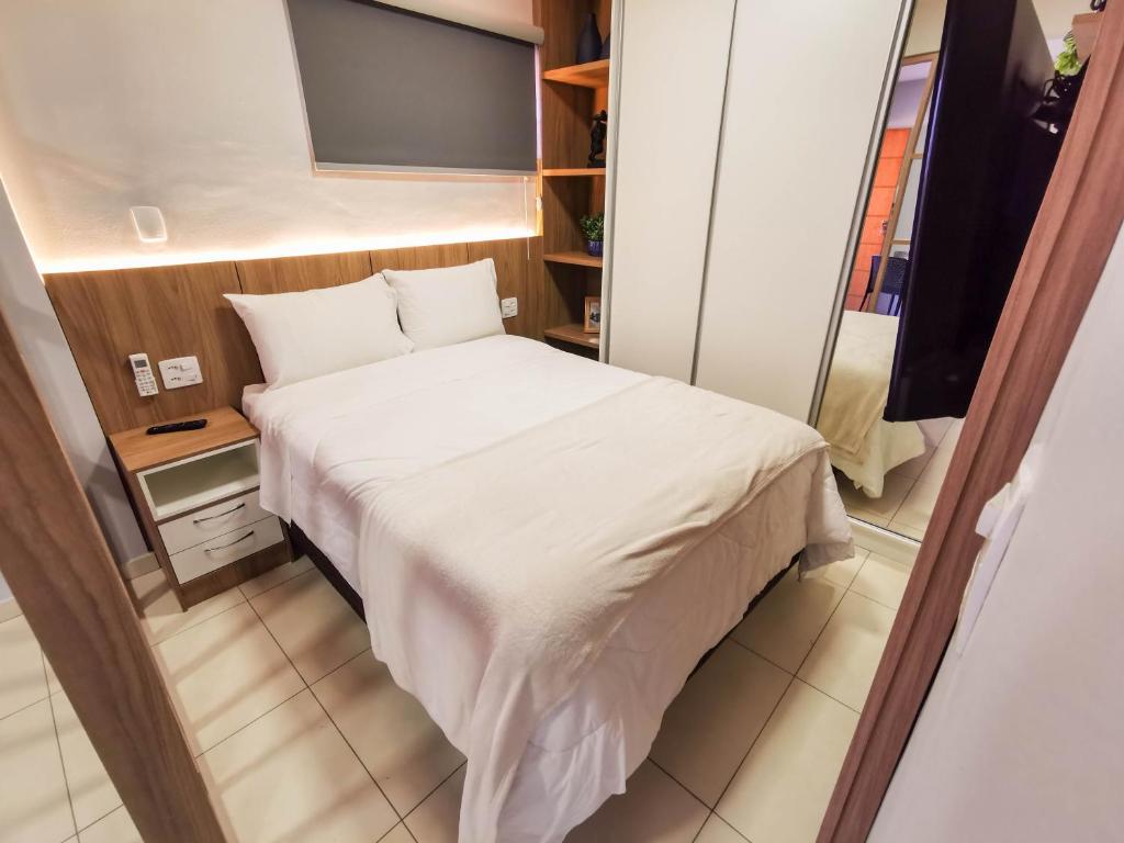 um pequeno quarto com uma cama e uma televisão em AP ap aps em São João del Rei