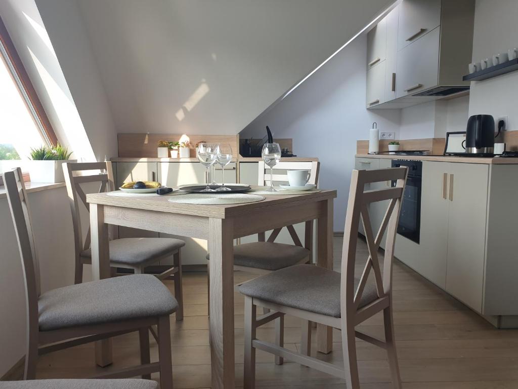 a kitchen with a table and chairs in a room at Near the airport- Apartments in Krakow