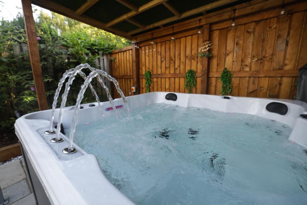 a bath tub with water coming out of it at Oasis Retreat Hot Tub Cupar in Cupar