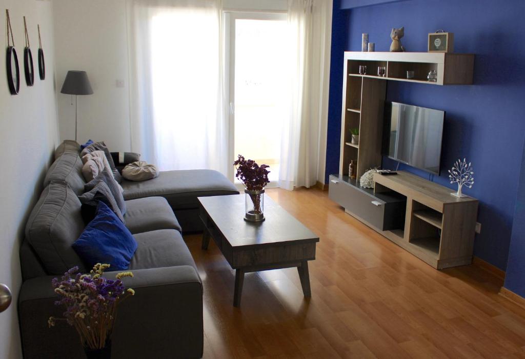 sala de estar con sofá y TV en Raise Limassol Urban Escape, en Limassol