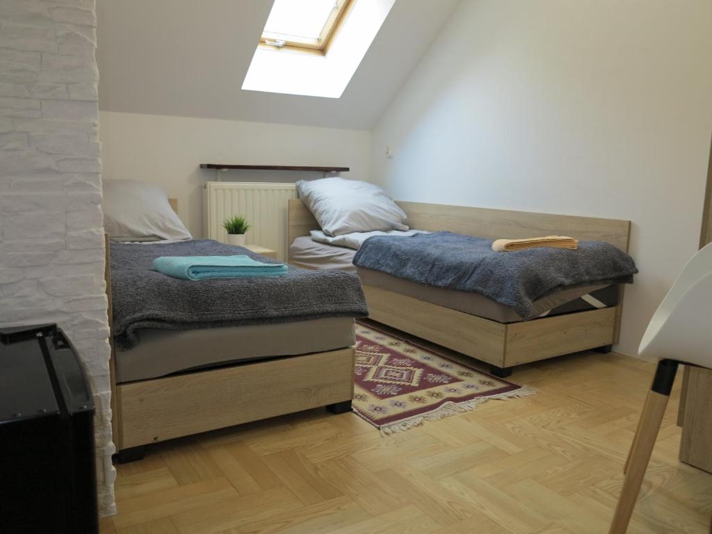 two twin beds in a room with a skylight at AirSpot Balice in Cholerzyn
