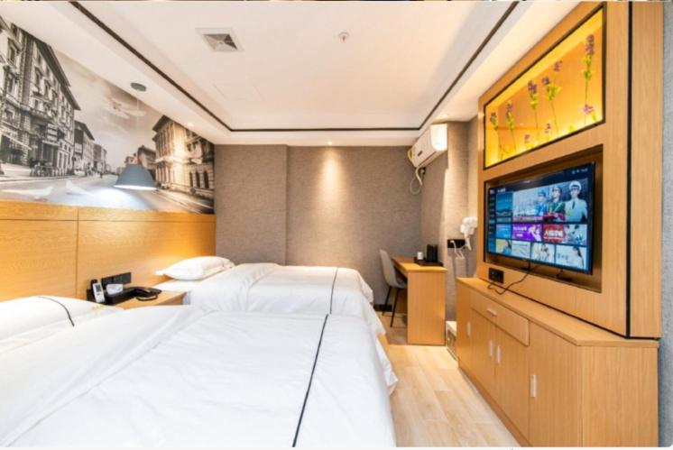 a hotel room with two beds and a flat screen tv at Yi Nuo Hotel Guangzhou in Guangzhou