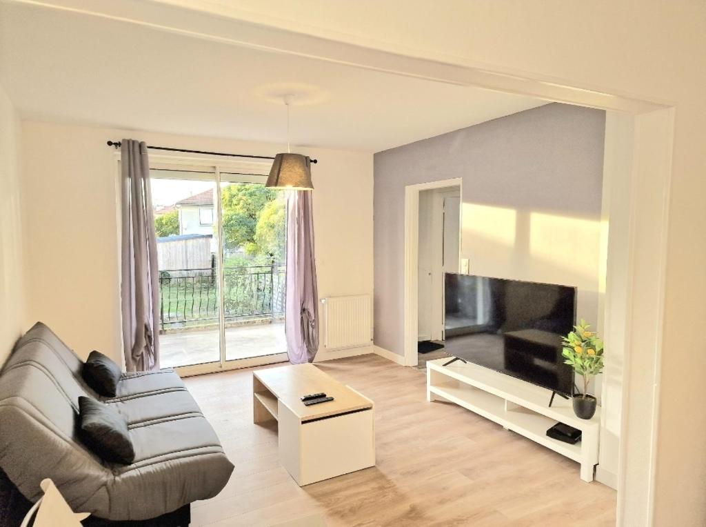 a living room with a couch and a tv at Maison à Aurillac - 3 chambres - Arrivée autonome in Aurillac