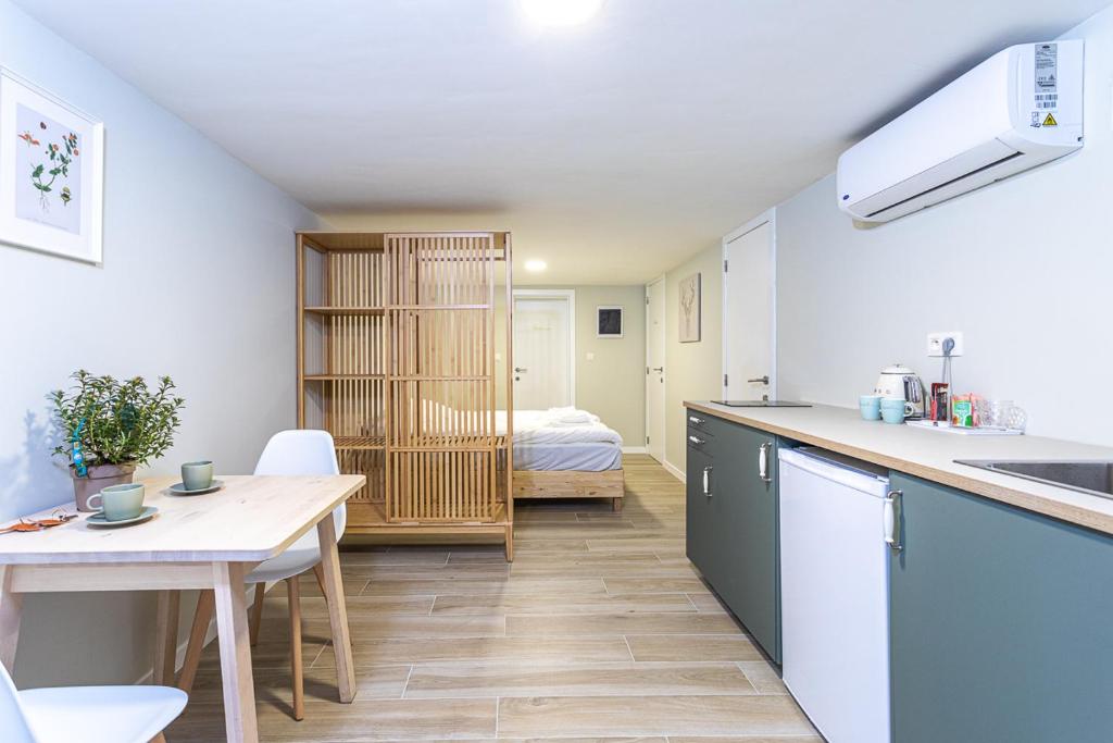 a kitchen and dining room with a table and a bedroom at Studio1 Van Lerius in Antwerp