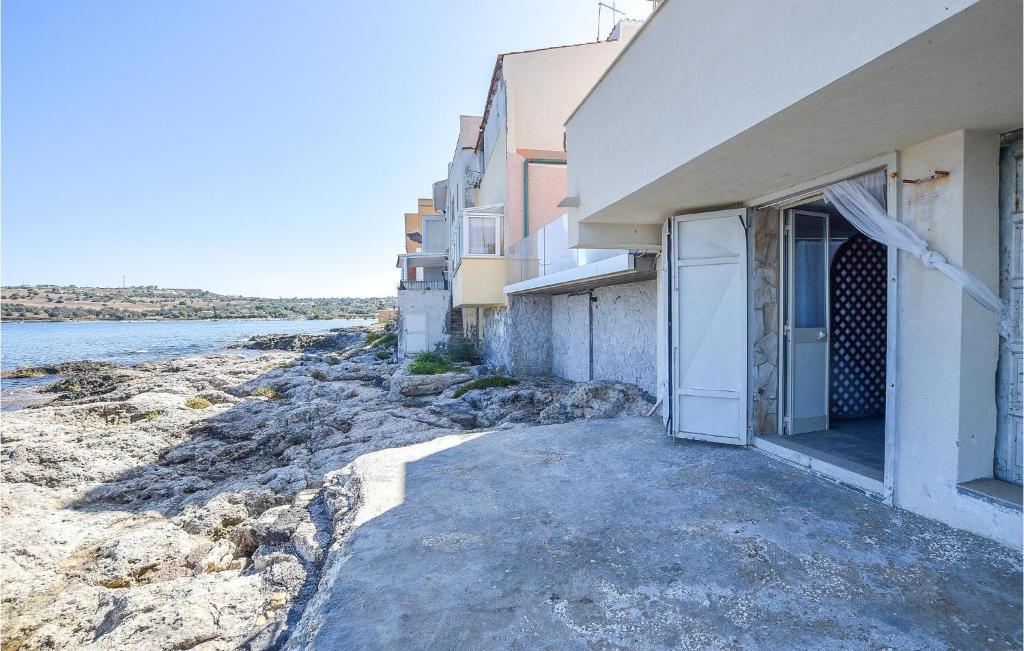 un edificio con una puerta abierta junto al agua en Gorgeous Apartment In Brucoli With Kitchen, en Brucoli