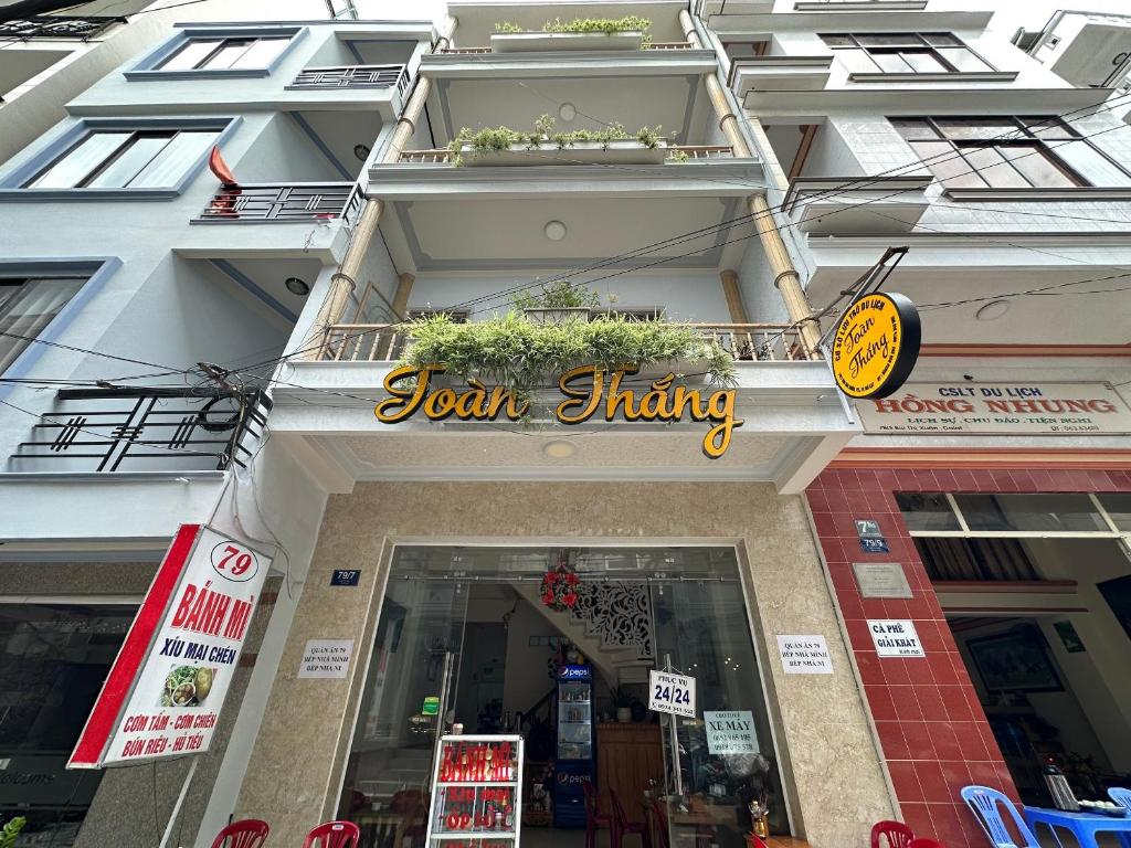 大叻的住宿－OYO 1206 Toan Thang Homestay，建筑物前面的商店,上面有标志