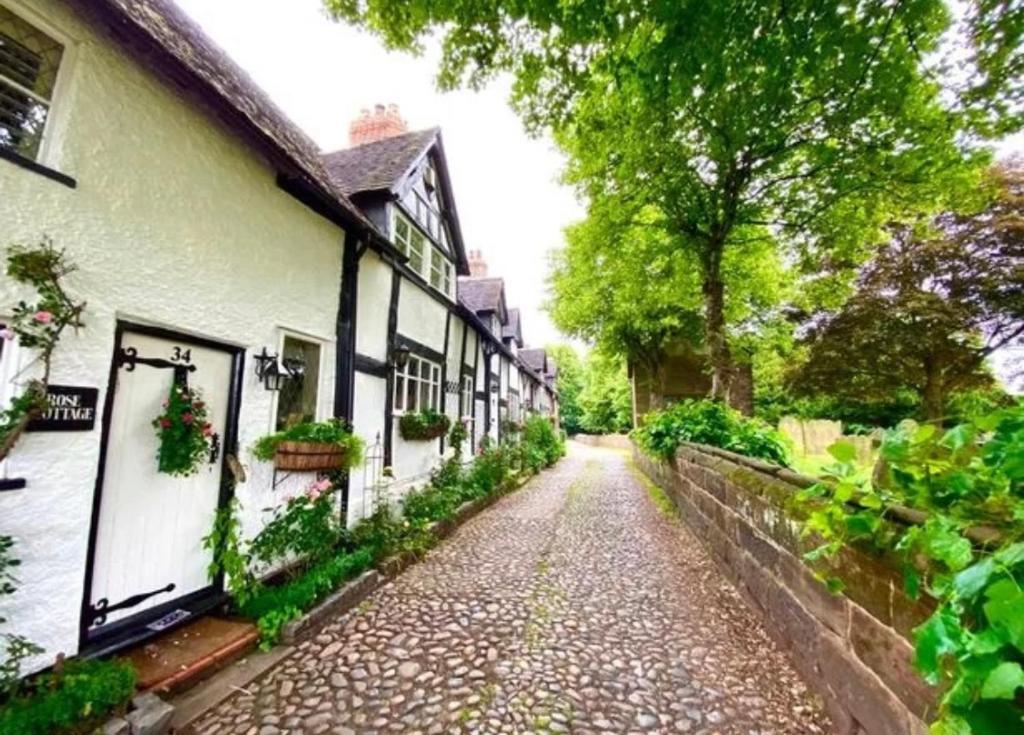 une rue pavée en face d'une maison blanche dans l'établissement Rose Cottage - 17th Century Idyllic Country Cottage in Picturesque Village with Great Pub, 