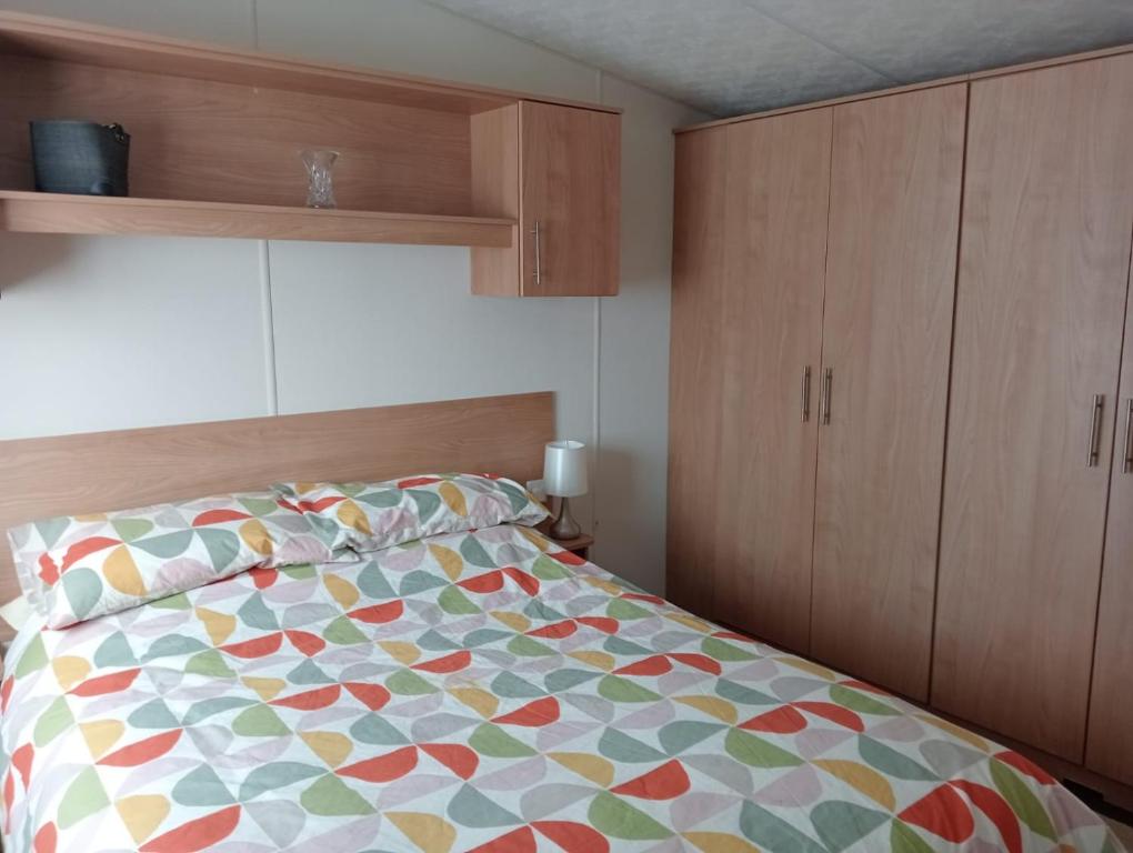 1 dormitorio con 1 cama con un edredón colorido en 19 Chaffron, en Hull