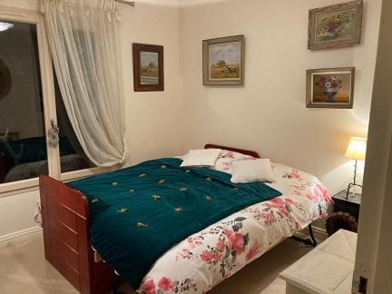 1 dormitorio con 1 cama con manta verde en MARTINEAU Idéal JO 2024, en La Celle-les-Bordes