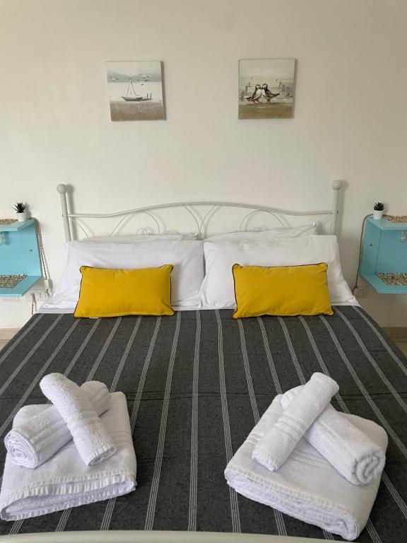 Holiday Gels appartamento vacanze Ostia في ليدو دي أوستيا: غرفة نوم عليها سرير وفوط