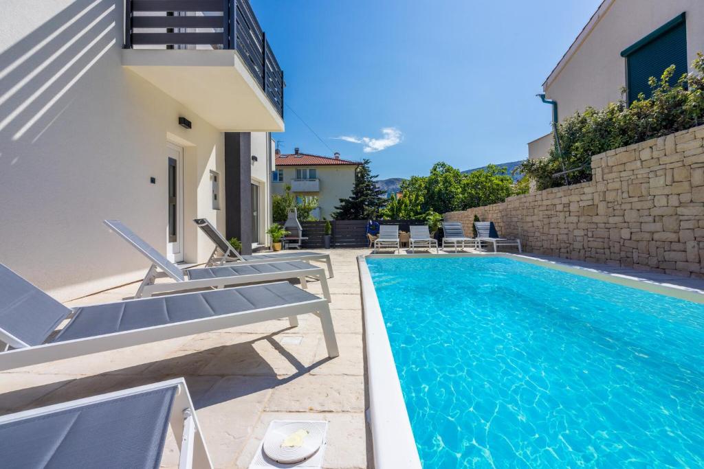 uma villa com uma piscina e mobiliário de pátio em Villa Ketty em Baska