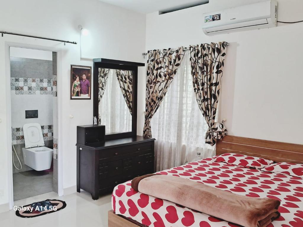 a bedroom with a red and white bed and a mirror at Love Villa in Kottiyam