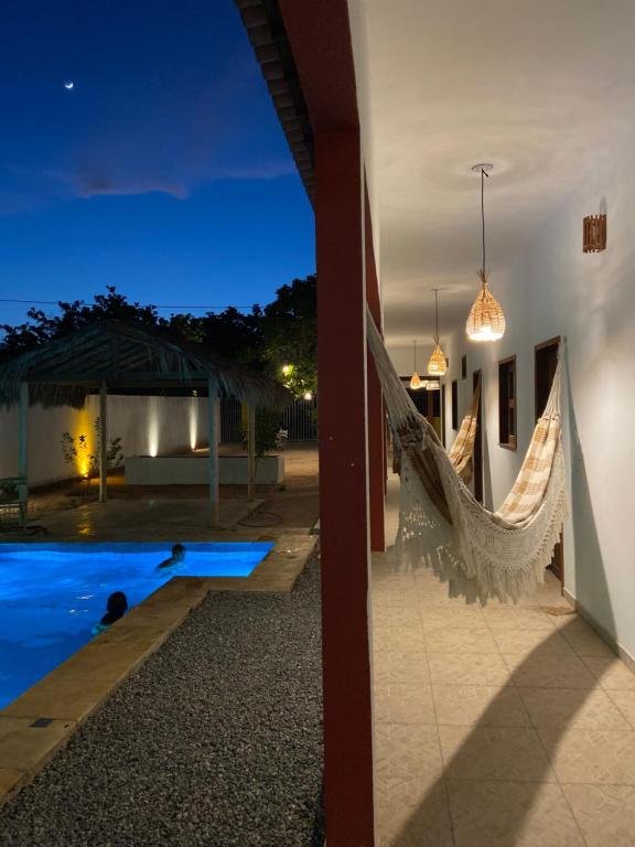 uma villa com uma rede de descanso ao lado de uma piscina à noite em Casa da Lagoa em Jijoca de Jericoacoara