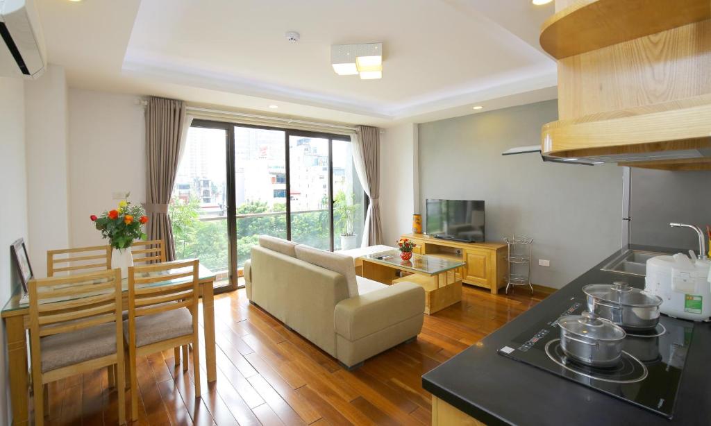 a kitchen and living room with a couch and a table at Investland in Truc Bach & serviced apartment in Hanoi