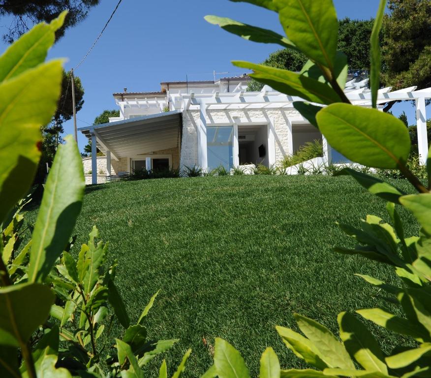 a lawn in front of a white house at Conero Suites in Numana