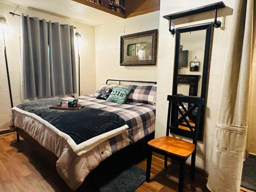 um quarto com uma cama com um espelho e uma cadeira em Acorn Hideaways Canton Secluded Sherlock Holmes Suite King Bed em Canton