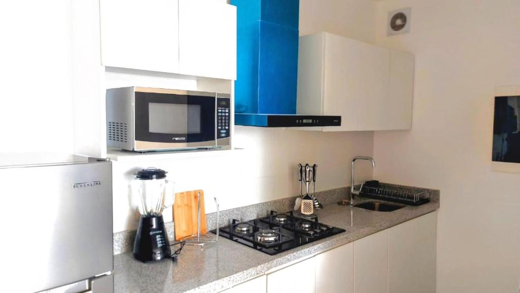 y cocina con fogones y microondas. en (T) Exclusivo departamento en Piura en Piura