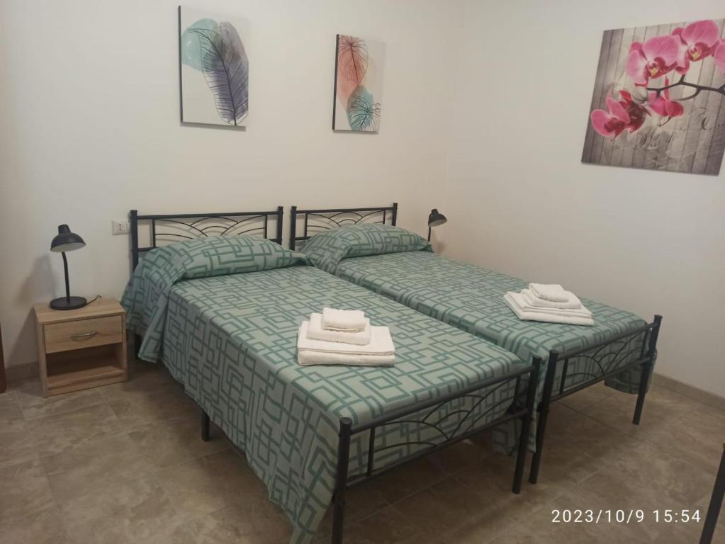 a bedroom with two beds with towels on them at VILLA VIOLA B & B in Baganzola