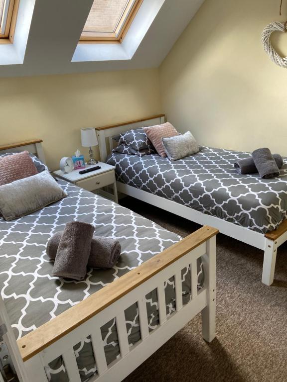 a bedroom with two beds and a ceiling with skylights at Ashton Gate Mews in Bristol
