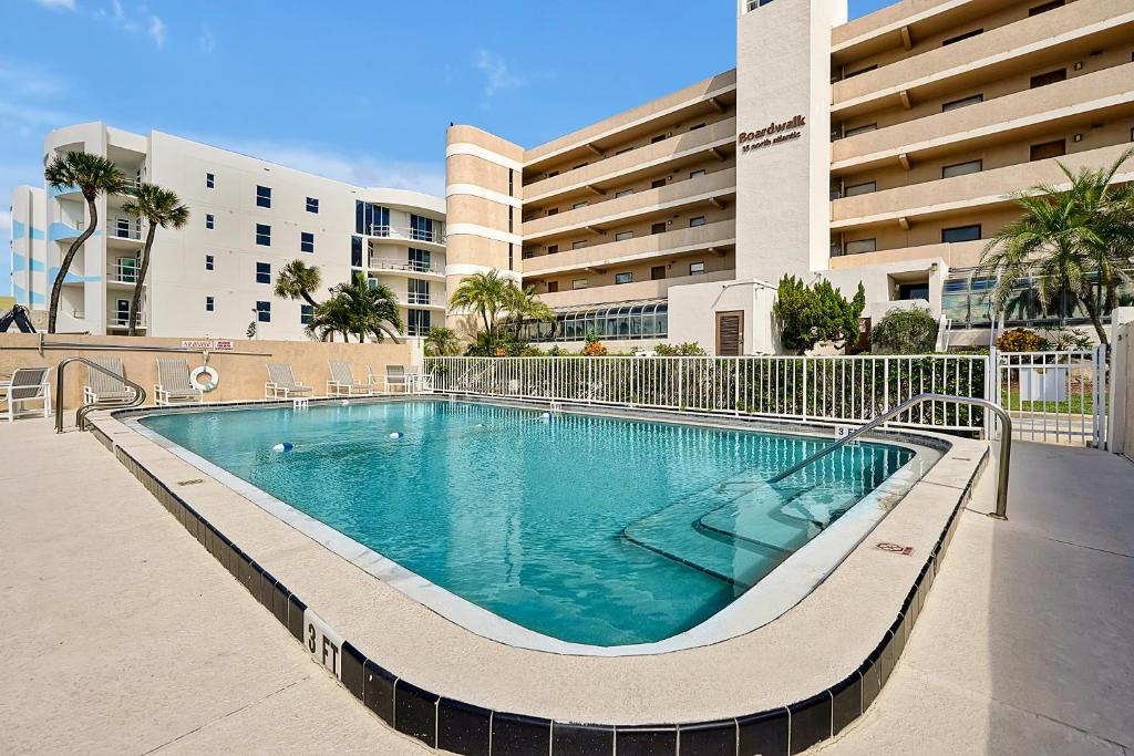 a swimming pool in front of a building at Direct Oceanfront Condo Amazing Views Cocoa Beach in Cocoa Beach