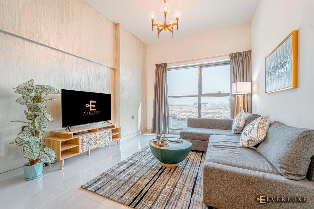 a living room with a couch and a tv at Lawnz-4 210 in Dubai