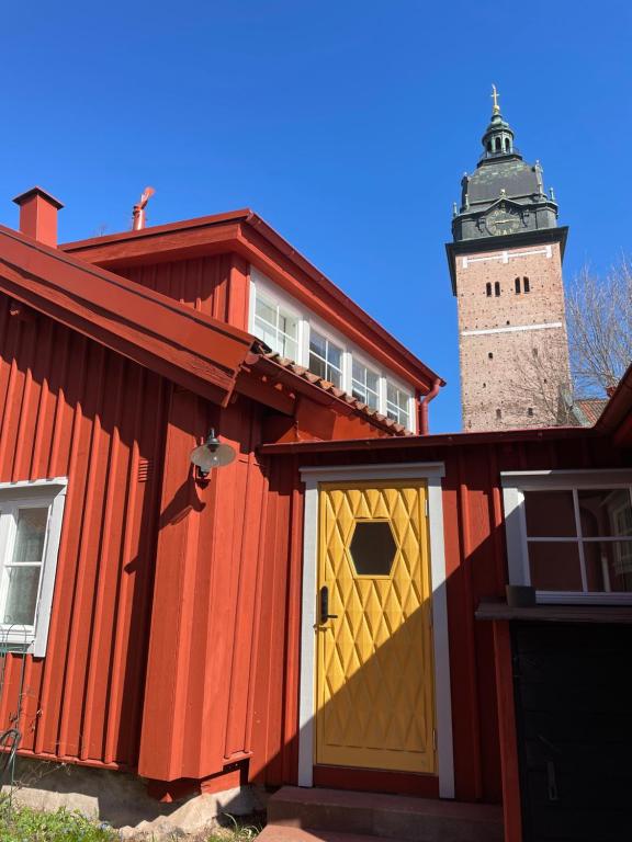 ein rotes Gebäude mit gelber Tür und Leuchtturm in der Unterkunft Historical idyll from the 17th century in Strängnäs