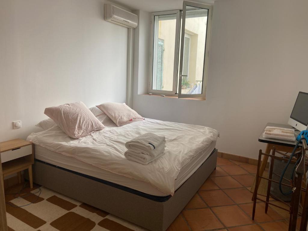 1 cama con 2 almohadas y una ventana en una habitación en Appartement de charme, vue sur le vieux port, en Marsella