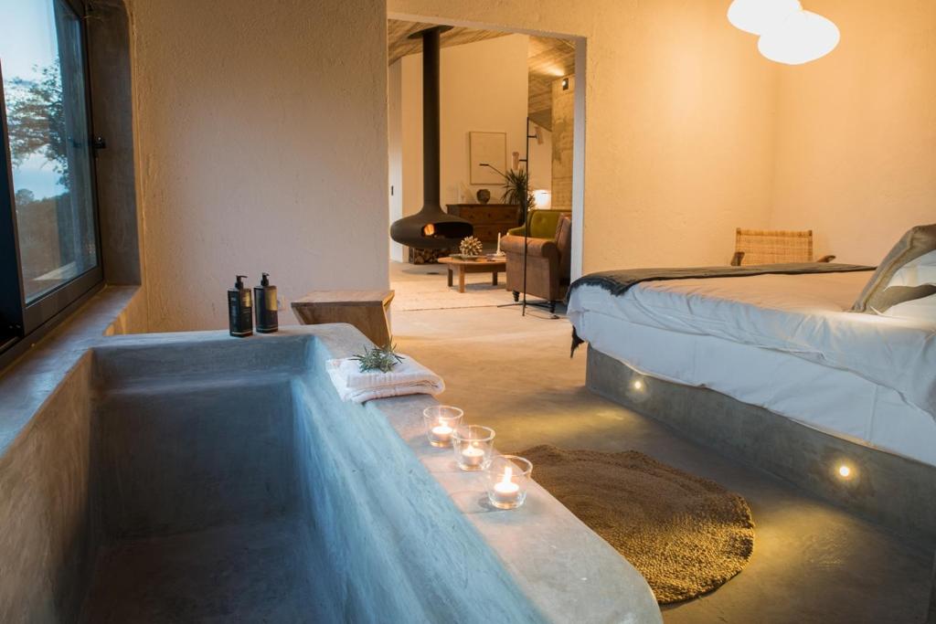a hotel room with a tub with a bed and a bedroom at Vigias -Eternal Landscapes in Marvão
