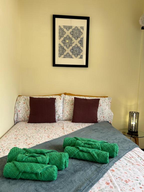 Una cama con una manta verde encima. en DREAM ANAGA, en Santa Cruz de Tenerife