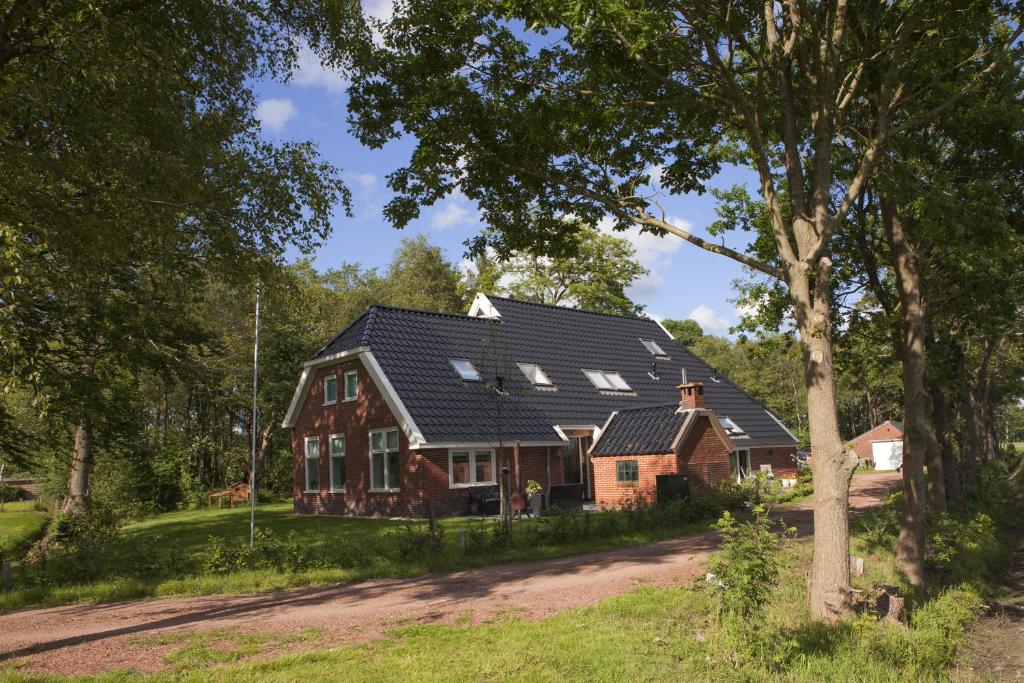 una casa grande con techo de gambrel en Logement de Kaap en Terheijl