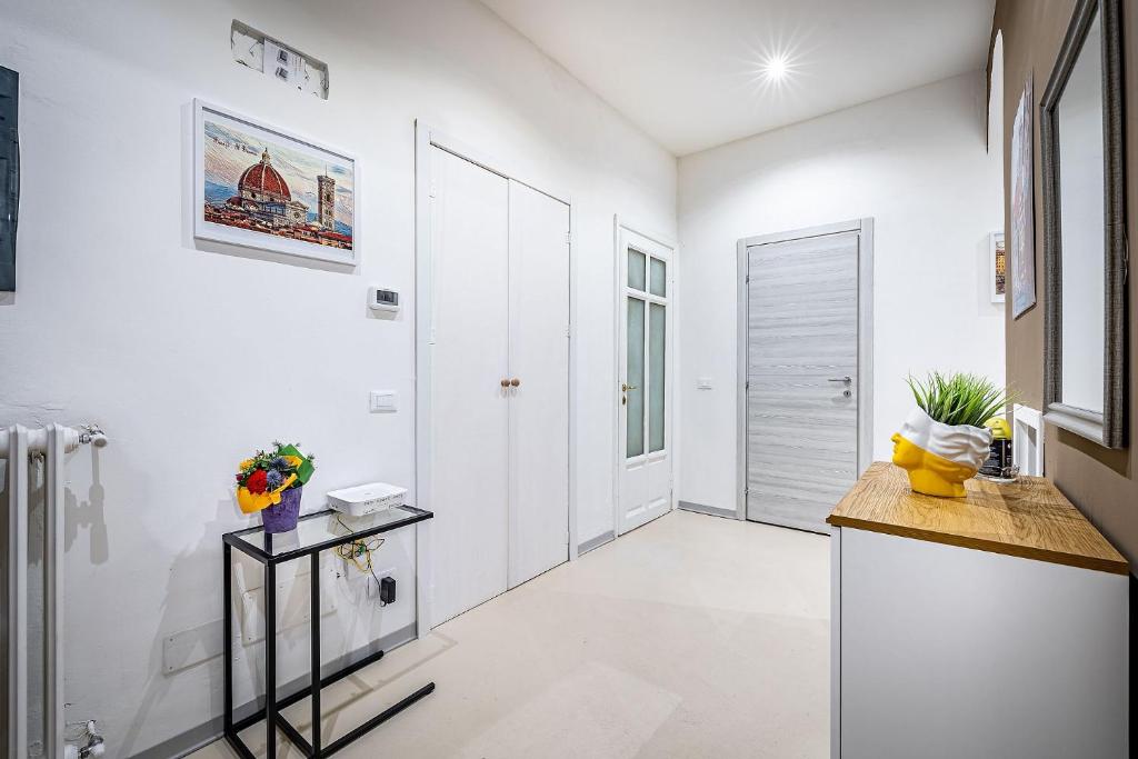 uma cozinha com paredes brancas e pisos brancos e um corredor em la loggia del porcellino em Florença