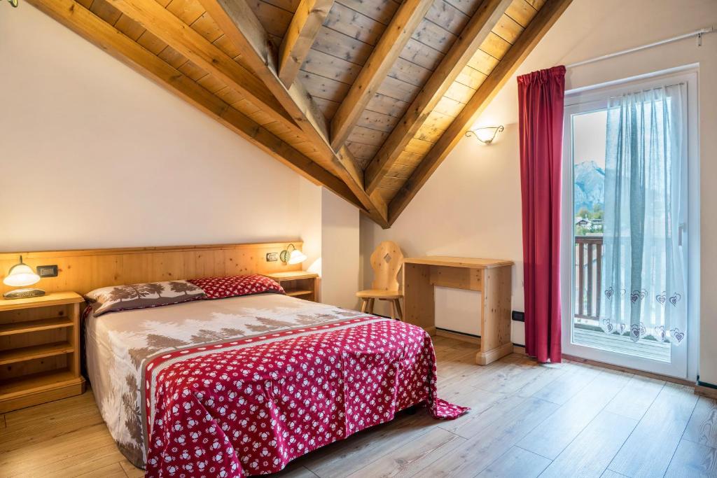 a bedroom with a bed and a large window at Giongo Residence Aparthotel 102 in Lavarone