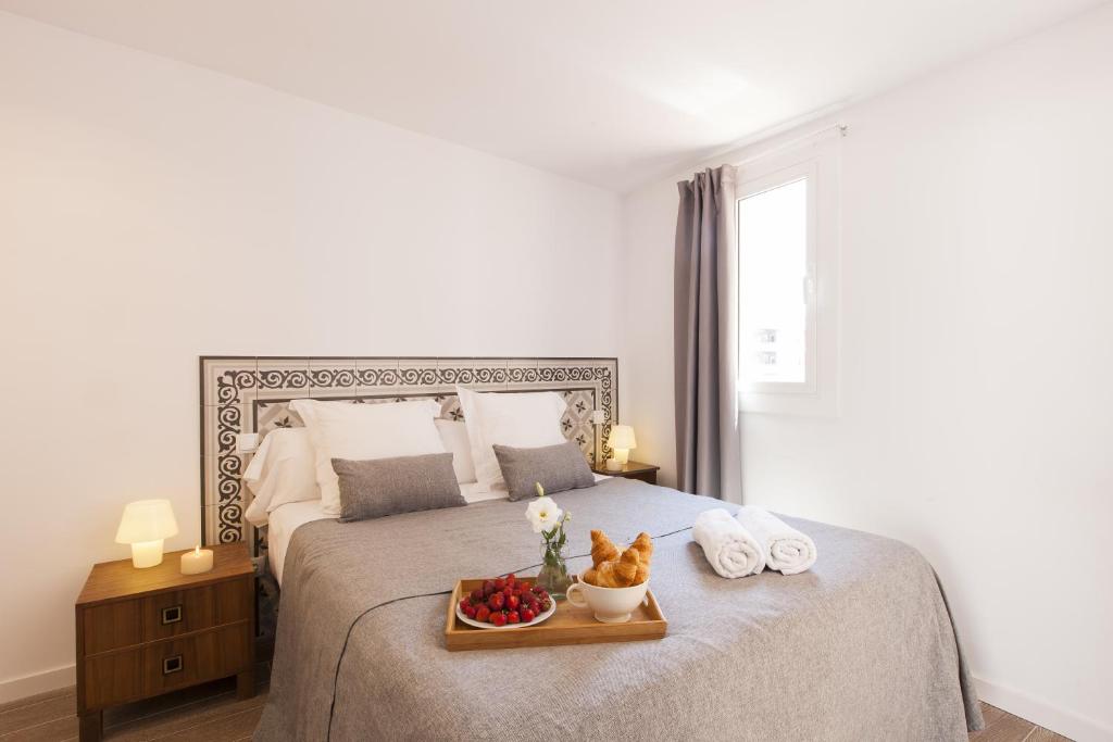 Un dormitorio con una cama con una bandeja de fruta. en Charming Flats by Aspasios, en Barcelona