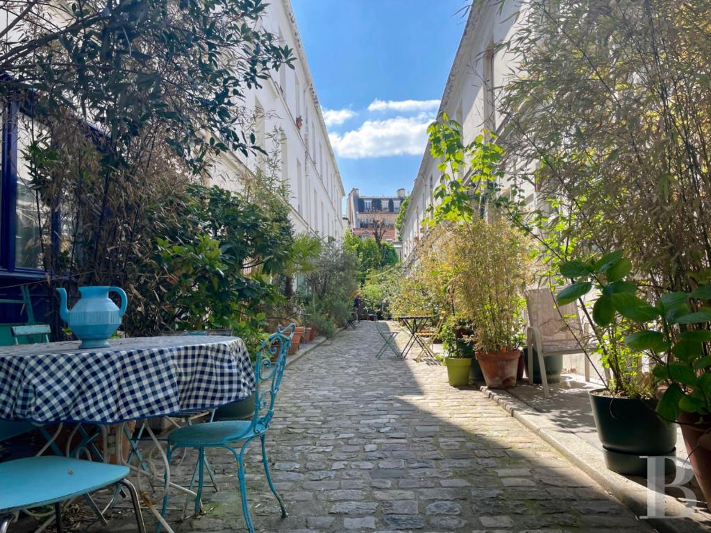 Une allée avec une table, des chaises et des plantes dans l'établissement Maison Antoinette Paris - Maison Nomade Chic, à Paris