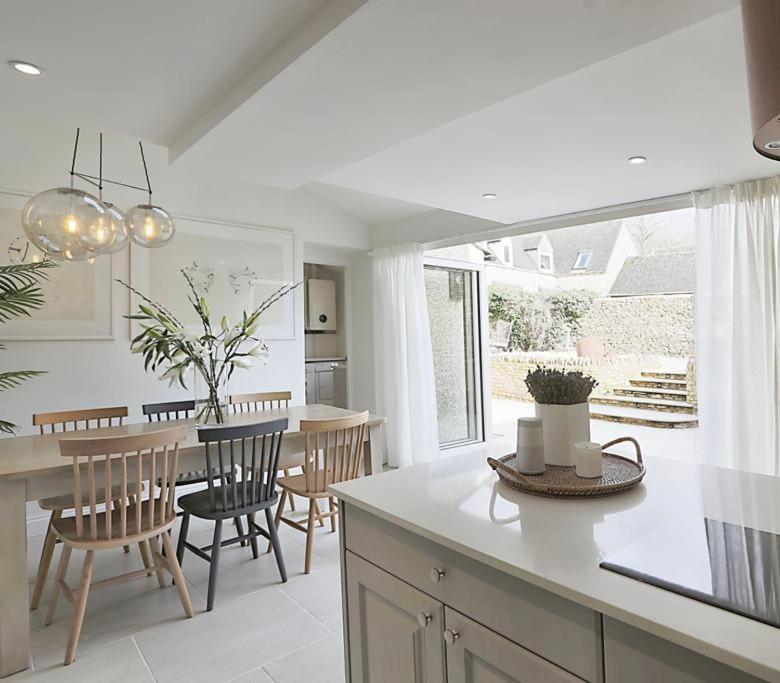 cocina y comedor con mesa y sillas en Luxury Cotswold Cottage with hot tub in Stow on the Wold!, en Stow on the Wold