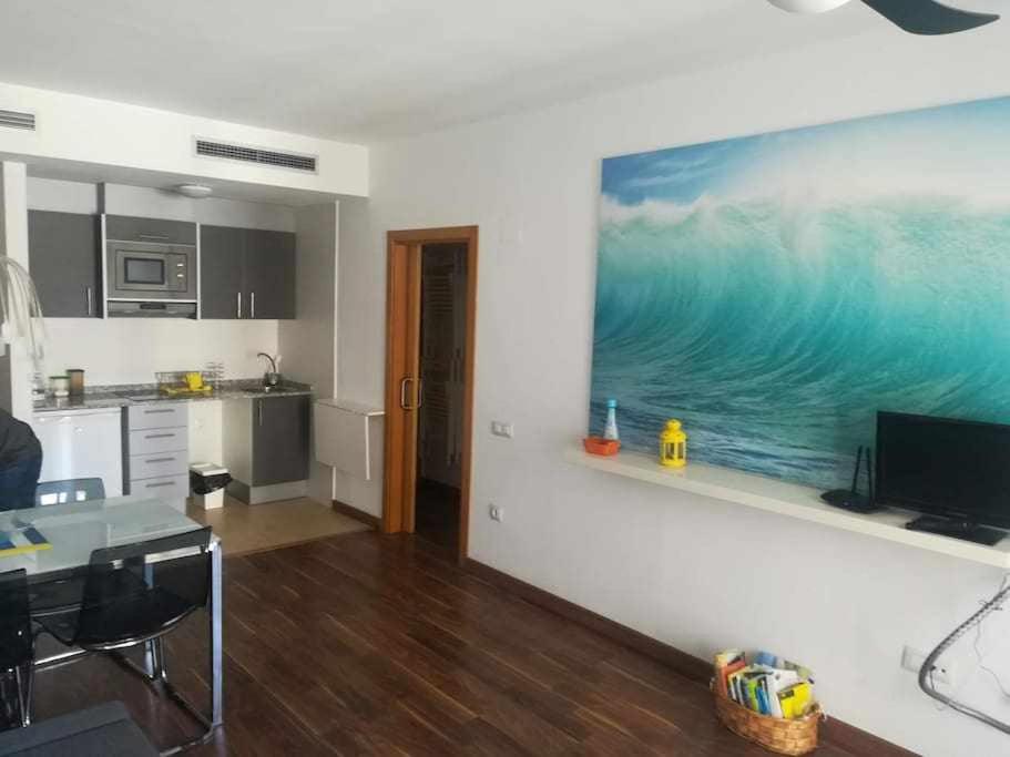 uma cozinha com uma pintura do oceano na parede em Apartamento Moderno with AirCo em Oliva