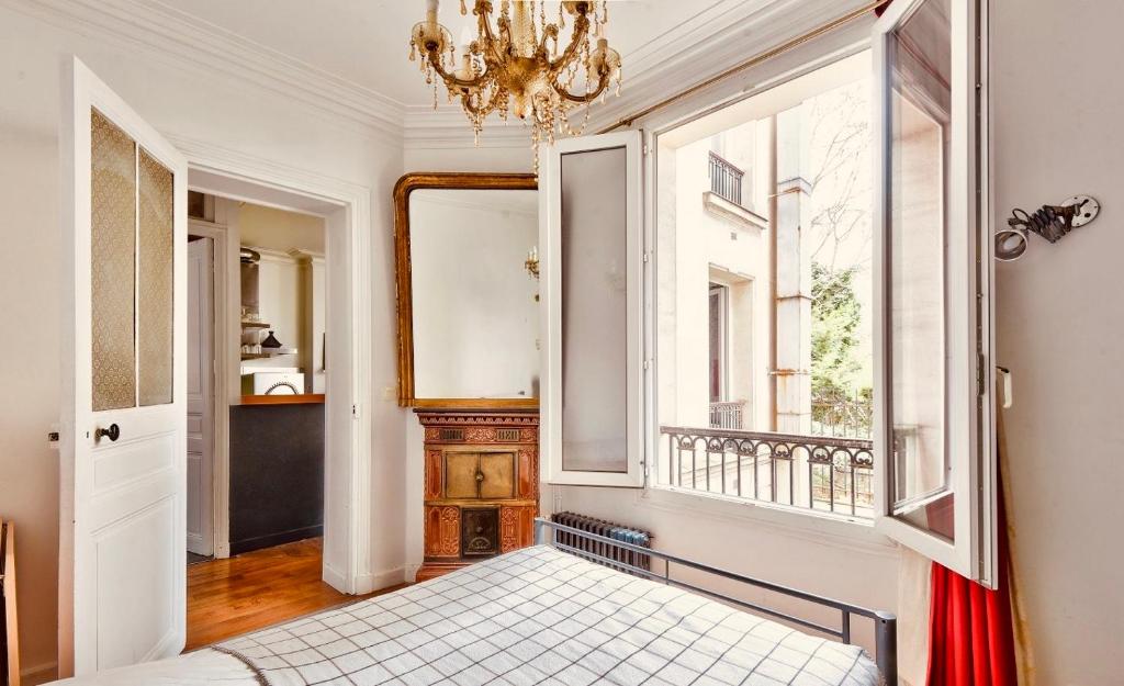 1 dormitorio con cama y ventana en Paris Welcome en París