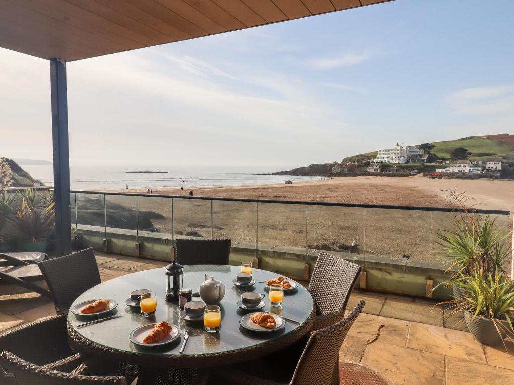 a table with food and a view of a beach at 4 Burgh Island Causeway in Kingsbridge