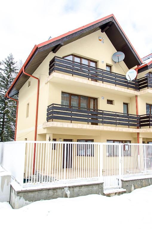 a house with a white fence in front of it at Holiday Vila Predeal in Predeal