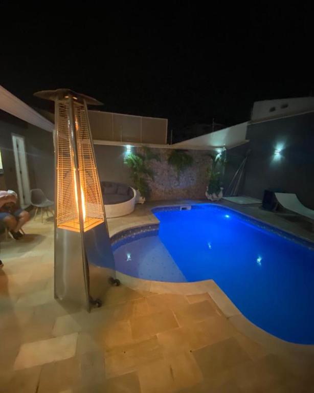 a swimming pool at night with a light next to it at CasaparkIndaiatuba in Indaiatuba