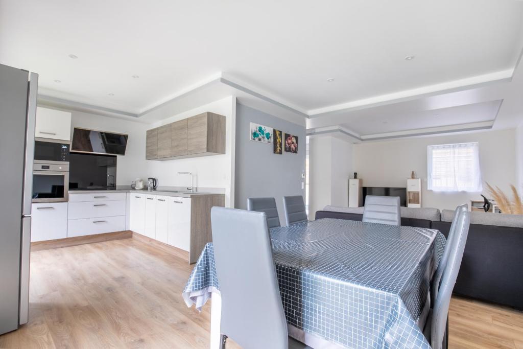 eine Küche und ein Wohnzimmer mit einem Tisch und Stühlen in der Unterkunft Maison duplex 3 chambres à 6km de Bordeaux centre in Floirac
