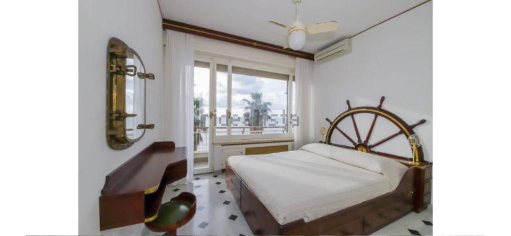 um quarto com uma cama, um espelho e uma janela em Sogno sul mare em Sestri Levante