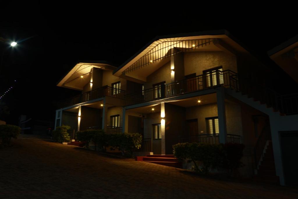 a large building at night with the moon behind it at MM Resorts in Yercaud