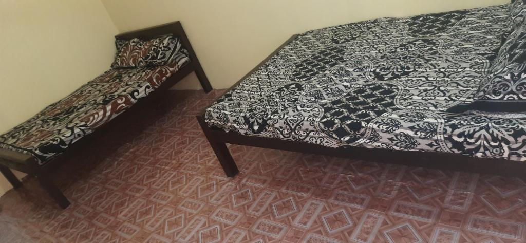 a room with a bed and a couch and a carpet at My guest rooms kattankudy in Kattankudi