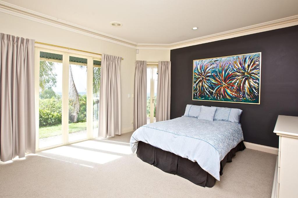 1 dormitorio con 1 cama y una pintura en la pared en Tranquil Garden Hideaway, en Ormeau