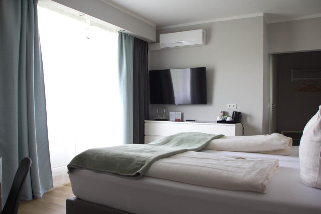 - une chambre avec un lit et une grande fenêtre dans l'établissement Hotel Senator, à Bielefeld