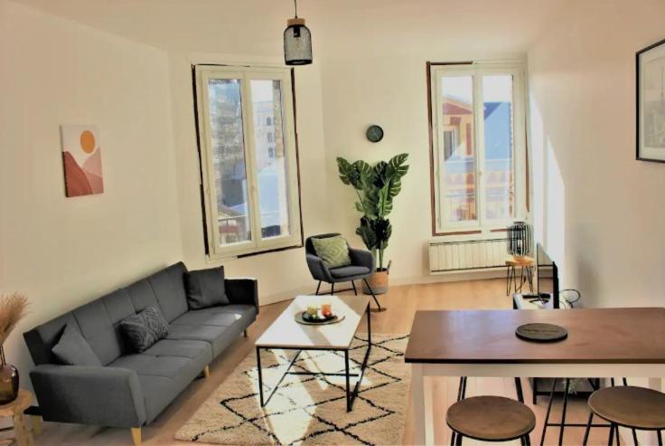 a living room with a couch and a table and chairs at Magnifique appartement in Le Havre